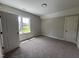 Neutral bedroom featuring carpeted floors, and natural light from a window showcasing the outdoor views at 165 Cotton Fields Ln # 25, Fuquay Varina, NC 27526
