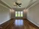 Bright primary bedroom with hardwood floors, tray ceilings, recessed lighting, and ample windows at 165 Cotton Fields Ln # 25, Fuquay Varina, NC 27526