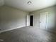 This spacious bedroom features a neutral color palette, carpet flooring, and two doors at 165 Cotton Fields Ln # 25, Fuquay Varina, NC 27526
