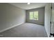 Neutral bedroom with carpeted floors and natural light from a single double hung window at 165 Cotton Fields Ln # 25, Fuquay Varina, NC 27526