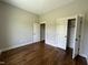 Spacious bedroom with hardwood floors, neutral paint, closet, and bright doorways at 165 Cotton Fields Ln # 25, Fuquay Varina, NC 27526