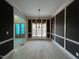 Dining room with black accent wall, white trim, hardwood floors, and modern light fixture at 165 Cotton Fields Ln # 25, Fuquay Varina, NC 27526