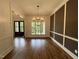 A modern dining room with wainscoting, hardwood floors, statement lighting, and views to the entryway at 165 Cotton Fields Ln # 25, Fuquay Varina, NC 27526