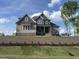 Beautiful two-story home featuring a combination of gray and beige siding, with a manicured lawn and brick retaining wall at 165 Cotton Fields Ln # 25, Fuquay Varina, NC 27526