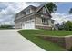 Side view of a gray home with a two-car garage and a concrete driveway on a manicured lawn at 165 Cotton Fields Ln # 25, Fuquay Varina, NC 27526