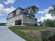A view from the side showing an open garage and driveway leading up to a grey and beige house at 165 Cotton Fields Ln # 25, Fuquay Varina, NC 27526