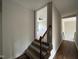 Inviting hallway showcasing hardwood floors and stairs leading to a carpeted room with a fan at 165 Cotton Fields Ln # 25, Fuquay Varina, NC 27526