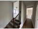 Hallway with wood floors and carpeted stairs leading to a room with a ceiling fan at 165 Cotton Fields Ln # 25, Fuquay Varina, NC 27526