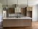 Modern kitchen boasts a large central island with sink, pendant lights and tile backsplash at 165 Cotton Fields Ln # 25, Fuquay Varina, NC 27526
