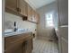 Convenient laundry room boasts stylish tile flooring and ample cabinet space at 165 Cotton Fields Ln # 25, Fuquay Varina, NC 27526
