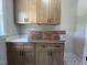 Bright laundry room featuring wood cabinets, a white countertop, and stylish patterned tile flooring at 165 Cotton Fields Ln # 25, Fuquay Varina, NC 27526
