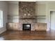 Elegant living room featuring a floor-to-ceiling stone fireplace, built-in cabinets, and hardwood floors at 165 Cotton Fields Ln # 25, Fuquay Varina, NC 27526