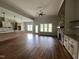 Open-concept living area with hardwood floors, a stone fireplace, and views into the kitchen at 165 Cotton Fields Ln # 25, Fuquay Varina, NC 27526