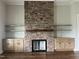 Stone fireplace with wooden beam and built-in cabinets provides a cozy focal point in the living room at 165 Cotton Fields Ln # 25, Fuquay Varina, NC 27526