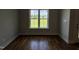 A well-lit room featuring hardwood floors and a large window showcasing an outdoor view at 165 Cotton Fields Ln # 25, Fuquay Varina, NC 27526