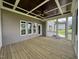 A screened-in porch boasts a decorative ceiling, ceiling fan, and wood flooring at 165 Cotton Fields Ln # 25, Fuquay Varina, NC 27526