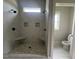 Newly tiled shower with pebble flooring, dual shower heads, and tiled corner shelves at 165 Cotton Fields Ln # 25, Fuquay Varina, NC 27526