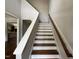 Carpeted staircase with a wooden handrail at 165 Cotton Fields Ln # 25, Fuquay Varina, NC 27526