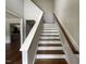 Staircase with white risers, dark wood stairs and railing at 165 Cotton Fields Ln # 25, Fuquay Varina, NC 27526