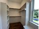 Bright walk-in closet includes wood flooring, a window, and shelving for optimal storage at 165 Cotton Fields Ln # 25, Fuquay Varina, NC 27526