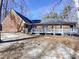Exterior of a brick home featuring an elevated deck and large backyard space at 204 Colonial Dr, Clayton, NC 27527