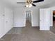 This spacious bedroom features neutral carpeting, a ceiling fan, and multiple doorways, offering versatility and flow at 204 Colonial Dr, Clayton, NC 27527