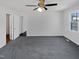 Spacious bedroom featuring neutral walls, plush gray carpet, and a modern ceiling fan with light at 204 Colonial Dr, Clayton, NC 27527