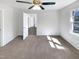 Neutral bedroom featuring a ceiling fan, carpet, a window and a door to a connecting room at 204 Colonial Dr, Clayton, NC 27527