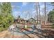 Expansive view of a home with a brick exterior, well-kept lawn, and welcoming benches at 221 Saddle Ridge Rd, Chapel Hill, NC 27514