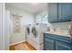 Bright laundry room features front loading washer/dryer and painted blue cabinetry at 221 Saddle Ridge Rd, Chapel Hill, NC 27514