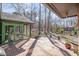 Brick patio with outdoor seating offers a peaceful view of the wooded backyard at 221 Saddle Ridge Rd, Chapel Hill, NC 27514