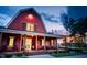 Charming two-story red barn-style home with a welcoming front porch and meticulously manicured landscaping at 270 Inspiration Way Way, Fuquay Varina, NC 27526