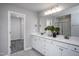 Bright bathroom featuring double vanity with white cabinets and a walk-in closet for ample storage at 281 Broomside Ave, Raleigh, NC 27603