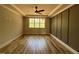 A spacious bedroom with a window, fan, and hardwood floors boasts neutral walls at 309 Deer Tail Ln # 42, Fuquay Varina, NC 27526