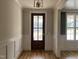 Elegant foyer with hardwood floors, white wainscoting, wood door and stylish light fixture at 309 Deer Tail Ln # 42, Fuquay Varina, NC 27526