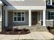 Inviting front porch with stone steps, white pillars, wood door, and professionally landscaped garden beds at 309 Deer Tail Ln # 42, Fuquay Varina, NC 27526