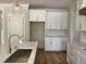 Bright kitchen featuring white cabinets, a stainless sink, and quartz countertops at 309 Deer Tail Ln # 42, Fuquay Varina, NC 27526