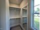 Walk-in closet with wooden clothing rod, shelving and full-length mirror by a window at 318 Deer Tail Ln # 35, Fuquay Varina, NC 27526