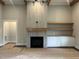 Close-up of a cozy fireplace with tiled surround, complemented by built-in shelving and cabinets in a spacious living room at 318 Deer Tail Ln # 35, Fuquay Varina, NC 27526
