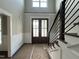 Elegant foyer featuring stylish paneled walls, a modern staircase with iron railings, and a view of the decorative front doors at 318 Deer Tail Ln # 35, Fuquay Varina, NC 27526
