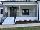Inviting front porch featuring a brick foundation, iron railings, and a stylish front door, surrounded by neat landscaping at 318 Deer Tail Ln # 35, Fuquay Varina, NC 27526