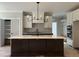 Beautiful kitchen island featuring sleek countertops, dark cabinetry, and a modern faucet, complemented by ample lighting at 318 Deer Tail Ln # 35, Fuquay Varina, NC 27526