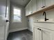 Functional laundry room with cabinets, a sink, and a window providing natural light at 318 Deer Tail Ln # 35, Fuquay Varina, NC 27526