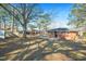 Green backyard with a detached garage, covered area, and a brick home at 326 Lake Dr, Wendell, NC 27591