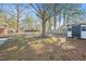 Spacious backyard with a storage shed, mature trees, and a wood fence at 326 Lake Dr, Wendell, NC 27591