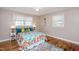 Cozy bedroom features colorful bedding, two windows for natural light, and wood flooring at 326 Lake Dr, Wendell, NC 27591