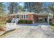 Inviting brick home with a carport, featuring a well-kept yard and gravel driveway at 326 Lake Dr, Wendell, NC 27591