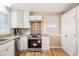 Bright kitchen with white cabinets, stainless steel appliances, decorative backsplash, and hardwood floors at 326 Lake Dr, Wendell, NC 27591