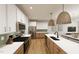 Modern kitchen featuring white and wood cabinets, stainless steel appliances, and stylish pendant lighting at 3930 Willow Gate Way, Raleigh, NC 27604