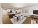 Open-concept living and dining area with hardwood floors, modern furnishings, and stylish pendant lighting at 3930 Willow Gate Way, Raleigh, NC 27604